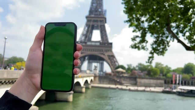 A woman's hand with vitiligo holds smartphone with green screen. Back view shot. Chroma key, close up woman hand holding phone with vertical green screen. High quality 4k footage