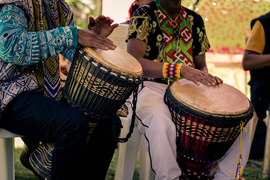Sao Paulo, SP, Brazil - November 11 2021: Men, with traditional indigenous clothes and handicrafts playing djembe details