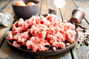 Raw mince lamb, ground mutton meat with herbs on a plate.