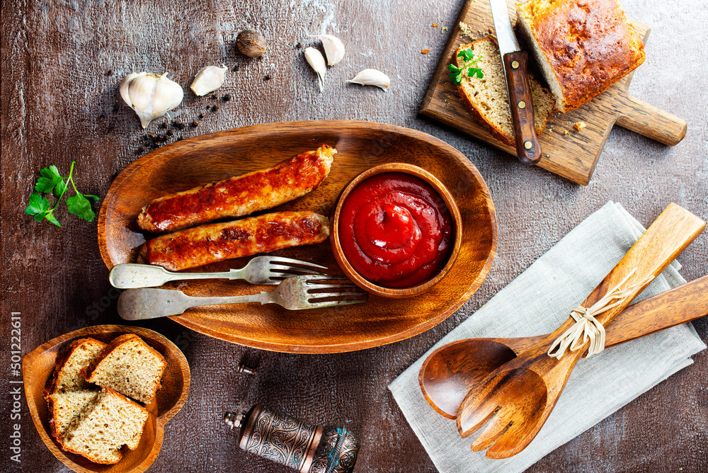 Canvas Prints Fried sausages with sauces and herbs on a wooden serving Board. Great beer snack on a dark background. Top view with copy space