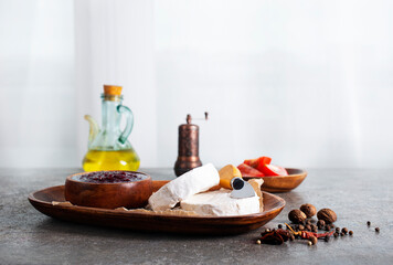 Camembert cheese with figs, raspberry jam. Round brie or camambert cheese on cutting board