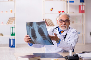 Naklejka na ściany i meble Old male doctor radiologist working in the clinic