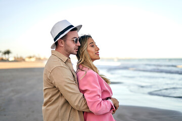 Happy couple hugging on the beach