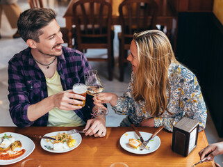 a couple toasting seated at a table in a restaurant