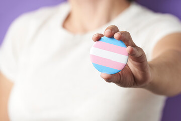 Unknown person showing a trans flag badge; gender diversity, identity pride