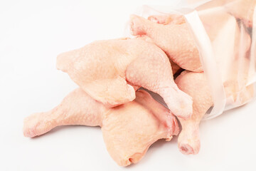Chicken fresh meat in a transparent bag.Frozen pieces of chicken leg on an isolated white background.