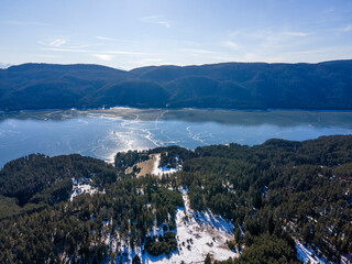 Aerial winter view of Dospat Reservoir covered with ice, Bulgaria