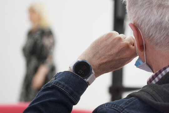 Elderly man looks thoughtfully at a passing woman. Concept of loneliness of the elderly. Concept of expectation and memories. Social assistance, support for the elderly or parents. No face