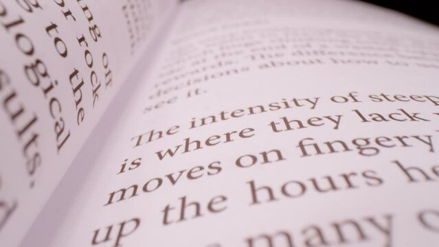 SUPER SLOW MOTION, CLOSE UP, PROBE LENS: Close up overview of open book pages in slow motion. Push in shot of printed open book pages. Probe lens shot of content in the open book.