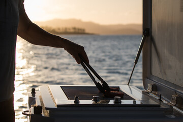 caucasian man tongs bbq water holiday ocean island meat flip grill trip boat sail relax sunset