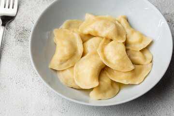 Traditional ukrainian dish vareniki served in a bowl with sour cream. Close up view of traditional Ukrainian food.