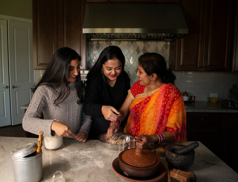 Mother and daughters in the kitchen - having fun 