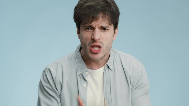 Nervous breakdown. Angry young man emotionally shouting and scolding with finger to camera, resenting furiously