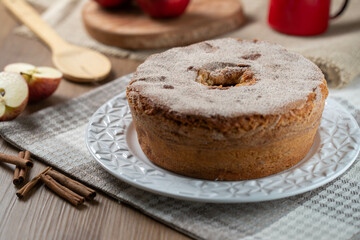 Sponge cake or chiffon cake with apples so soft and delicious sliced ​​with ingredients: cinnamon, eggs, flour, apples on wooden table. Home bakery concept for background and wallpaper