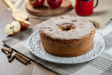 Sponge cake or chiffon cake with apples so soft and delicious sliced ​​with ingredients: cinnamon, eggs, flour, apples on wooden table. Home bakery concept for background and wallpaper