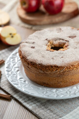 Sponge cake or chiffon cake with apples so soft and delicious sliced ​​with ingredients: cinnamon, eggs, flour, apples on wooden table. Home bakery concept for background and wallpaper
