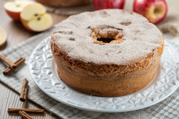 Fototapeta na wymiar Sponge cake or chiffon cake with apples so soft and delicious sliced ​​with ingredients: cinnamon, eggs, flour, apples on wooden table. Home bakery concept for background and wallpaper