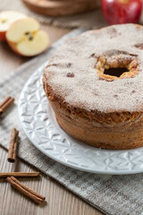 Sponge cake or chiffon cake with apples so soft and delicious sliced ​​with ingredients: cinnamon, eggs, flour, apples on wooden table. Home bakery concept for background and wallpaper