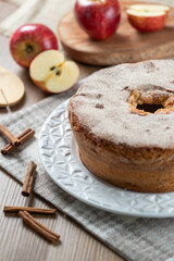 Sponge cake or chiffon cake with apples so soft and delicious sliced ​​with ingredients: cinnamon, eggs, flour, apples on wooden table. Home bakery concept for background and wallpaper