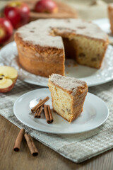 piece of Sponge cake or chiffon cake with apples so soft and delicious sliced ​​with ingredients: cinnamon, eggs, flour, apples on wooden table. Home bakery concept for background and wallpaper