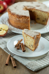 piece of Sponge cake or chiffon cake with apples so soft and delicious sliced ​​with ingredients: cinnamon, eggs, flour, apples on wooden table. Home bakery concept for background and wallpaper