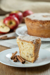 piece of Sponge cake or chiffon cake with apples so soft and delicious sliced ​​with ingredients: cinnamon, eggs, flour, apples on wooden table. Home bakery concept for background and wallpaper