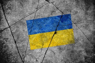 An image of the flag of Ukraine on a wall with a crack. A crisis.