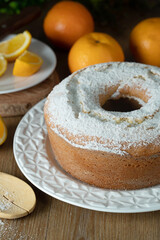 Moist orange fruit cake on plate with orange slices on wooden table. Delicious breakfast, traditional English tea time. Orange cake recipe.