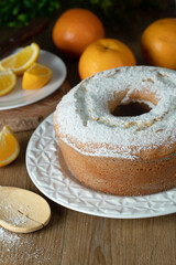 Moist orange fruit cake on plate with orange slices on wooden table. Delicious breakfast, traditional English tea time. Orange cake recipe.