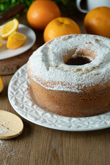 Moist orange fruit cake on plate with orange slices on wooden table. Delicious breakfast, traditional English tea time. Orange cake recipe.