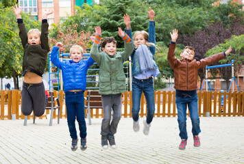 Happy kids jump and play outside. High quality photo