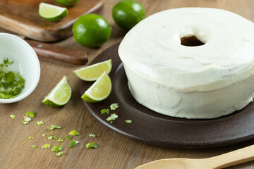 Moist lemon fruit cake on plate with lemon slices on wooden table. Delicious breakfast, traditional tea time. Lemon cake recipe.