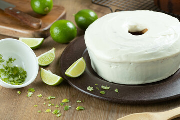 Moist lemon fruit cake on plate with lemon slices on wooden table. Delicious breakfast, traditional tea time. Lemon cake recipe.