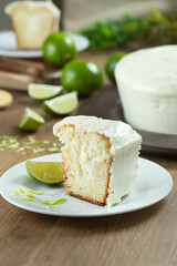 Close up piece of Moist lemon fruit cake on plate with lemon slices on wooden table. Delicious breakfast, traditional tea time. Lemon cake recipe.