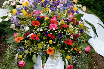 many colorful flowers on a grave after a funeral