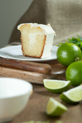 Close up piece of Moist lemon fruit cake on plate with lemon slices on wooden table. Delicious breakfast, traditional tea time. Lemon cake recipe.