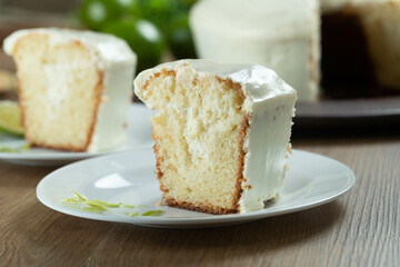 Close up piece of Moist lemon fruit cake on plate with lemon slices on wooden table. Delicious breakfast, traditional tea time. Lemon cake recipe.