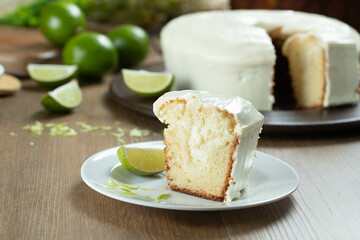 Close up piece of Moist lemon fruit cake on plate with lemon slices on wooden table. Delicious...