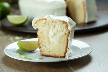 Close up piece of Moist lemon fruit cake on plate with lemon slices on wooden table. Delicious breakfast, traditional tea time. Lemon cake recipe.