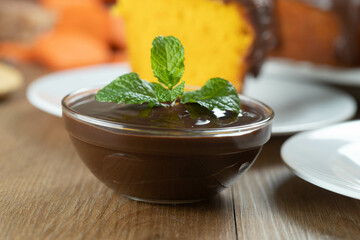 chocolate sauce mousse with mint in glass jar on wooden table