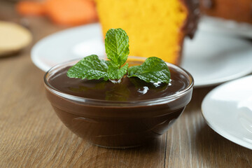 chocolate sauce mousse with mint in glass jar on wooden table