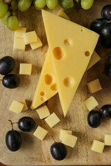 Cheese cut with fruits.Mazdar cheese triangles, gouda cheese cubes and black and green...