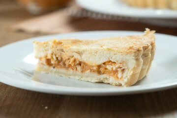 Close up piece of Chicken pie with cottage cheese, tomatoes, onion and olives on wooden table and white plate.