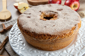 Sponge cake or chiffon cake with apples so soft and delicious sliced ​​with ingredients: cinnamon, eggs, flour, apples on wooden table. Home bakery concept for background and wallpaper