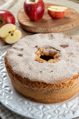 Sponge cake or chiffon cake with apples so soft and delicious sliced ​​with ingredients: cinnamon, eggs, flour, apples on wooden table. Home bakery concept for background and wallpaper