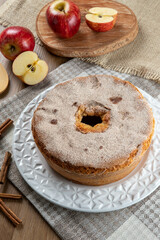 Sponge cake or chiffon cake with apples so soft and delicious sliced ​​with ingredients: cinnamon, eggs, flour, apples on wooden table. Home bakery concept for background and wallpaper. Top view.
