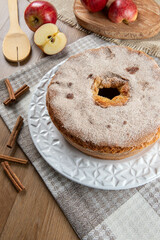 Sponge cake or chiffon cake with apples so soft and delicious sliced ​​with ingredients: cinnamon, eggs, flour, apples on wooden table. Home bakery concept for background and wallpaper. Top view.