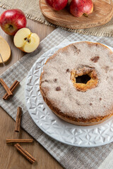 Sponge cake or chiffon cake with apples so soft and delicious sliced ​​with ingredients: cinnamon, eggs, flour, apples on wooden table. Home bakery concept for background and wallpaper. Top view.
