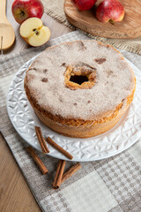 Sponge cake or chiffon cake with apples so soft and delicious sliced ​​with ingredients: cinnamon, eggs, flour, apples on wooden table. Home bakery concept for background and wallpaper. Top view.