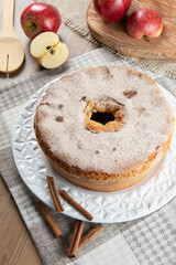 Sponge cake or chiffon cake with apples so soft and delicious sliced ​​with ingredients: cinnamon, eggs, flour, apples on wooden table. Home bakery concept for background and wallpaper. Top view.